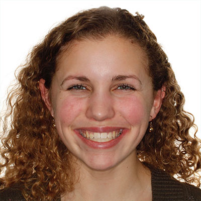 Teen smiling with straight, well-aligned teeth and a broad, confident smile after orthodontic treatment.